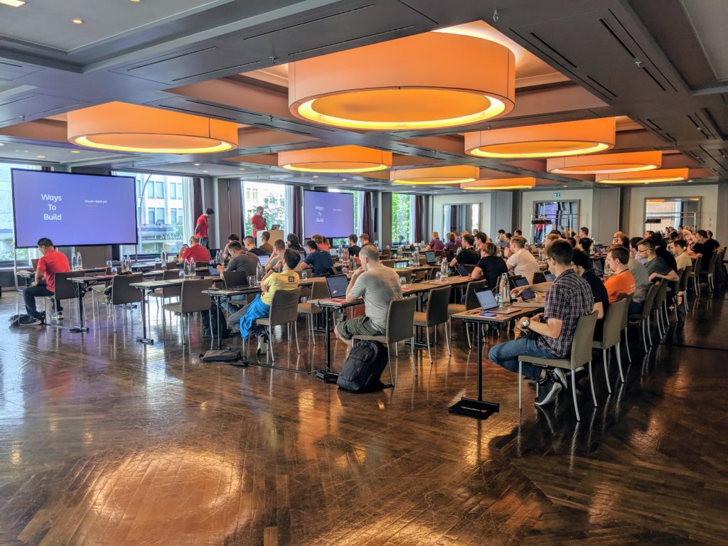 Developers watching a presentation in a large bright room